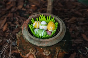 a clay pot filled with eggs sitting on top of grass