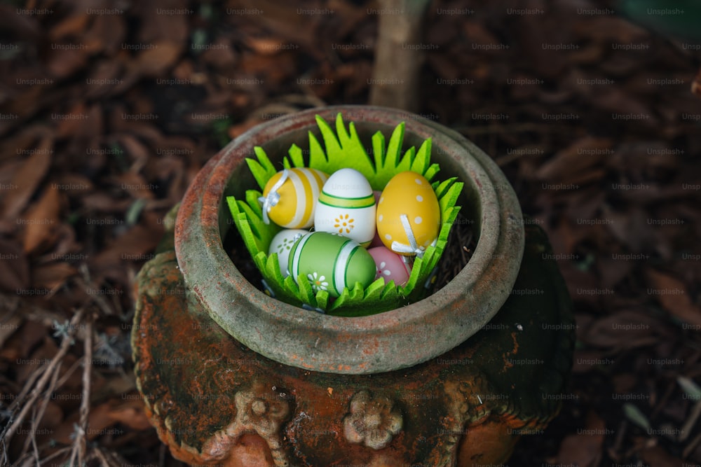 a clay pot filled with eggs sitting on top of grass