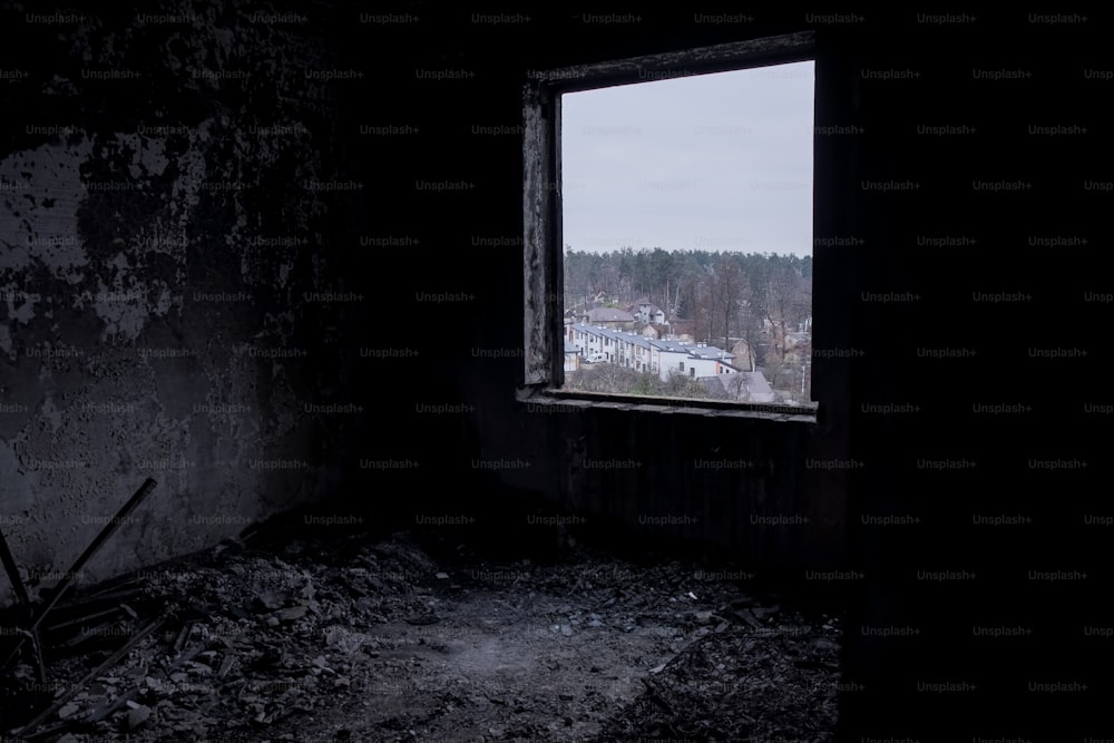 une chambre sombre avec une fenêtre et une vue sur une ville