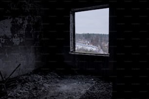 una habitación oscura con una ventana y una vista de una ciudad