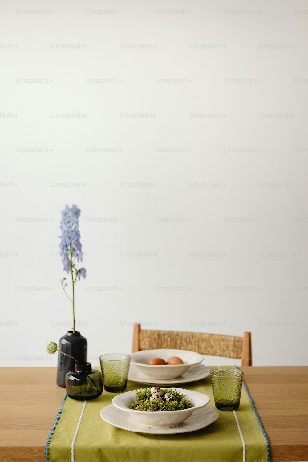a table topped with plates of food next to a vase of flowers