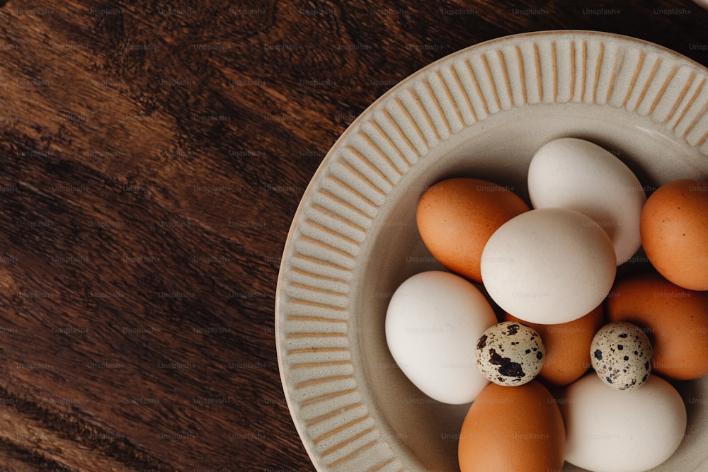 una ciotola bianca piena di uova sopra un tavolo di legno