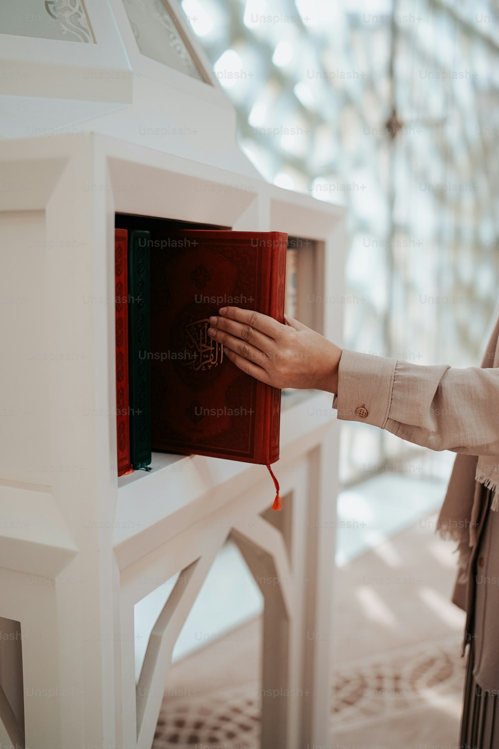 uma mulher está segurando um livro vermelho em sua mão