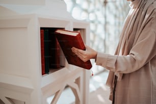 a woman is holding a book in her hand