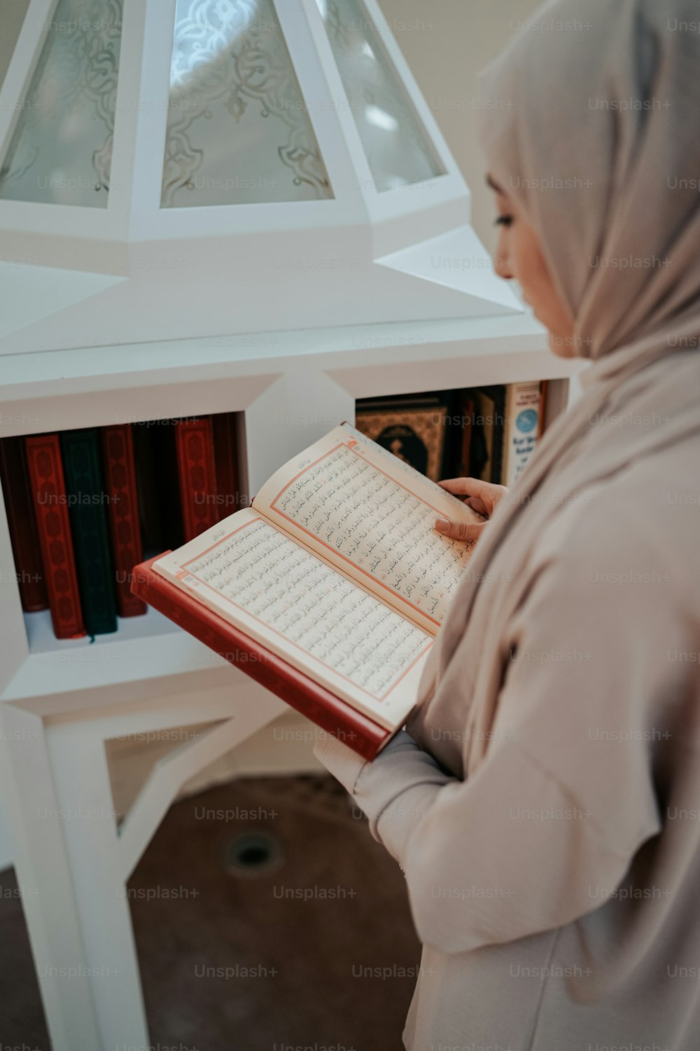 Una donna con l'hijab sta leggendo un libro