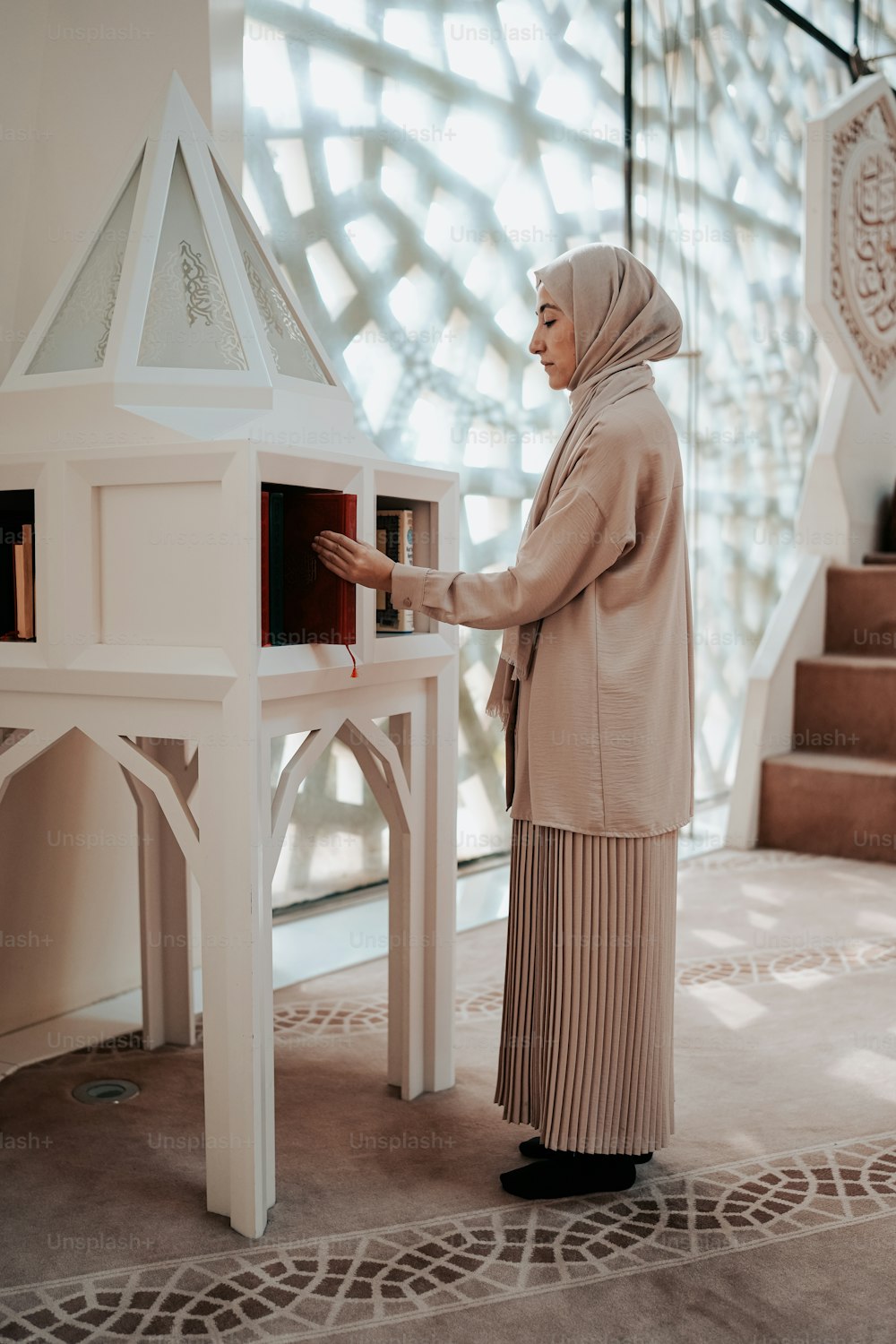 a woman standing in front of a doll house