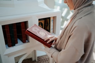 Eine Frau im Hijab hält ein Buch in der Hand