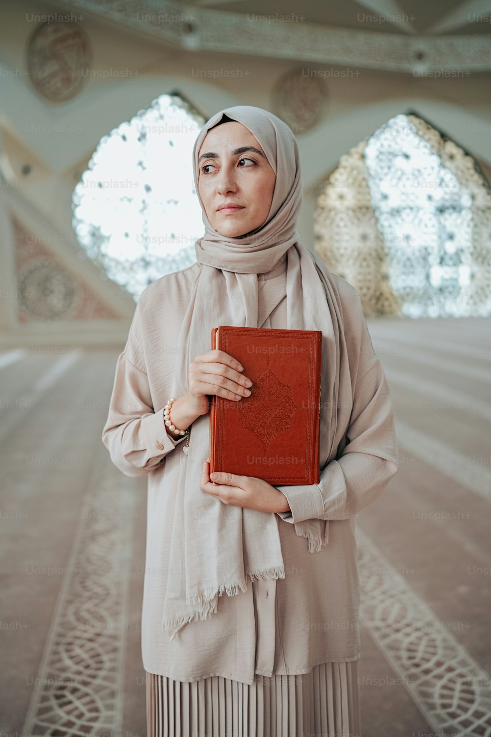 Eine Frau im Hijab hält ein Buch