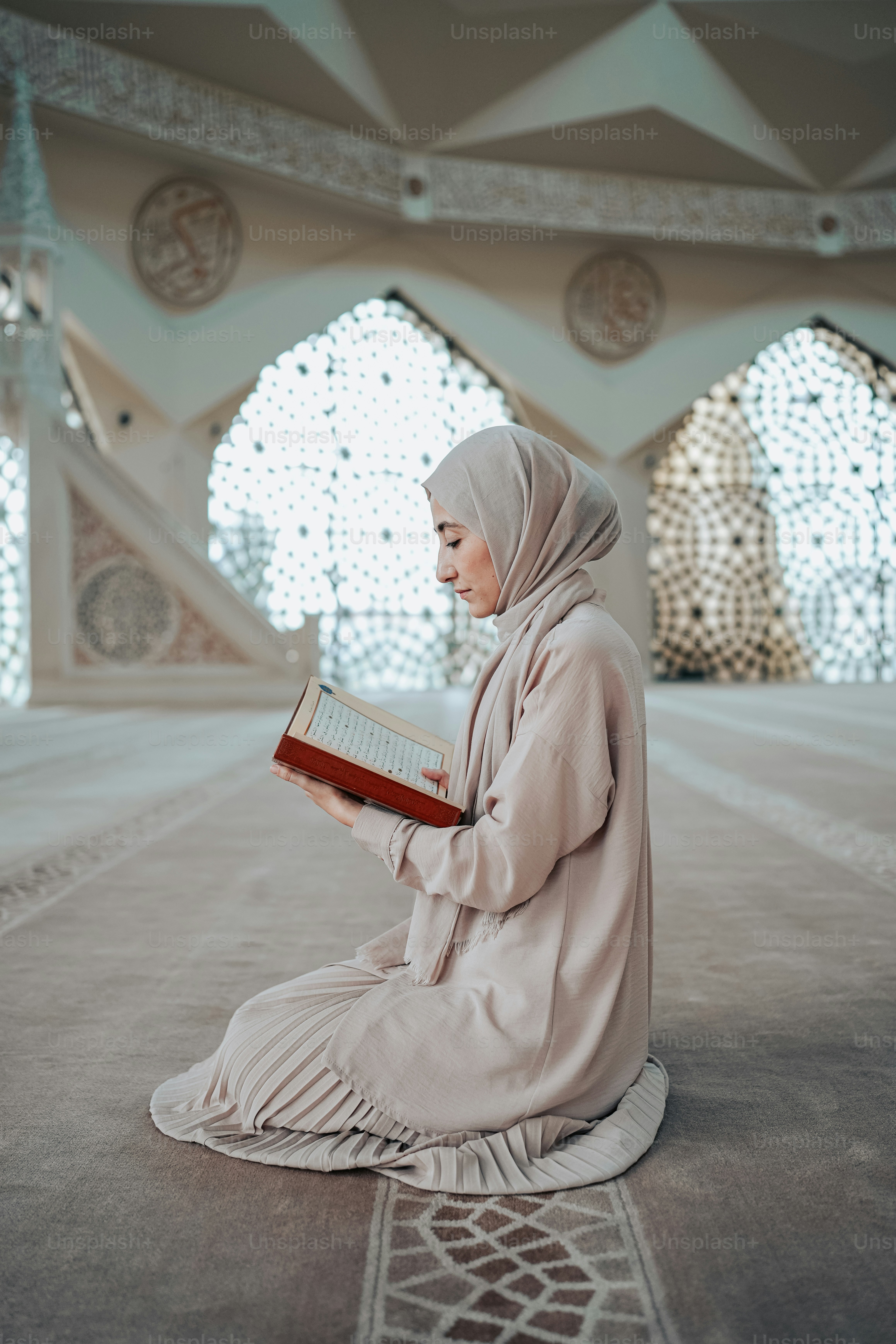 seorang wanita duduk di lantai membaca buku