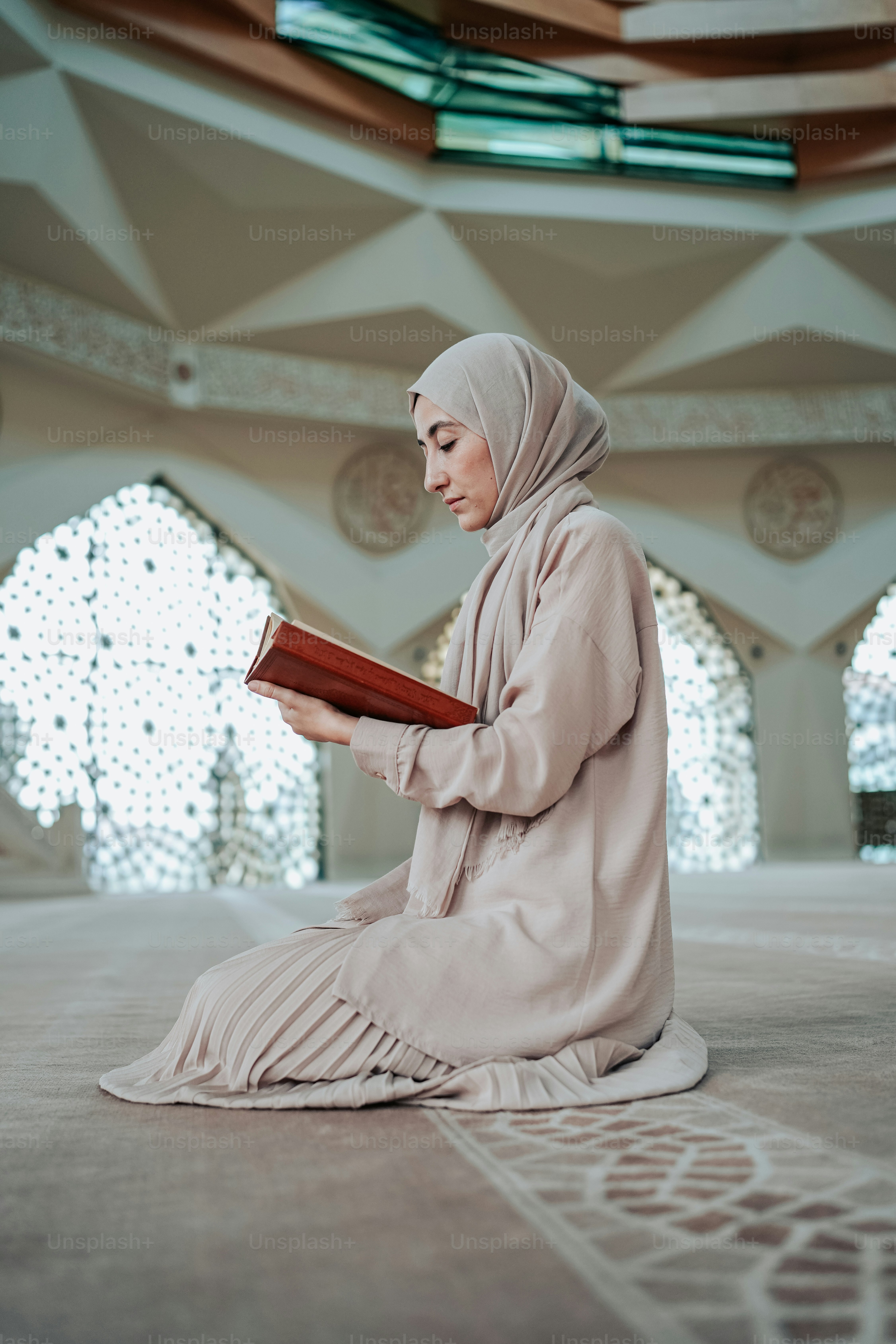 seorang wanita duduk di lantai membaca buku