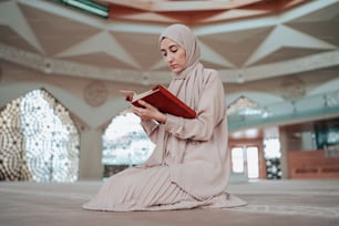 a woman sitting on the floor reading a book