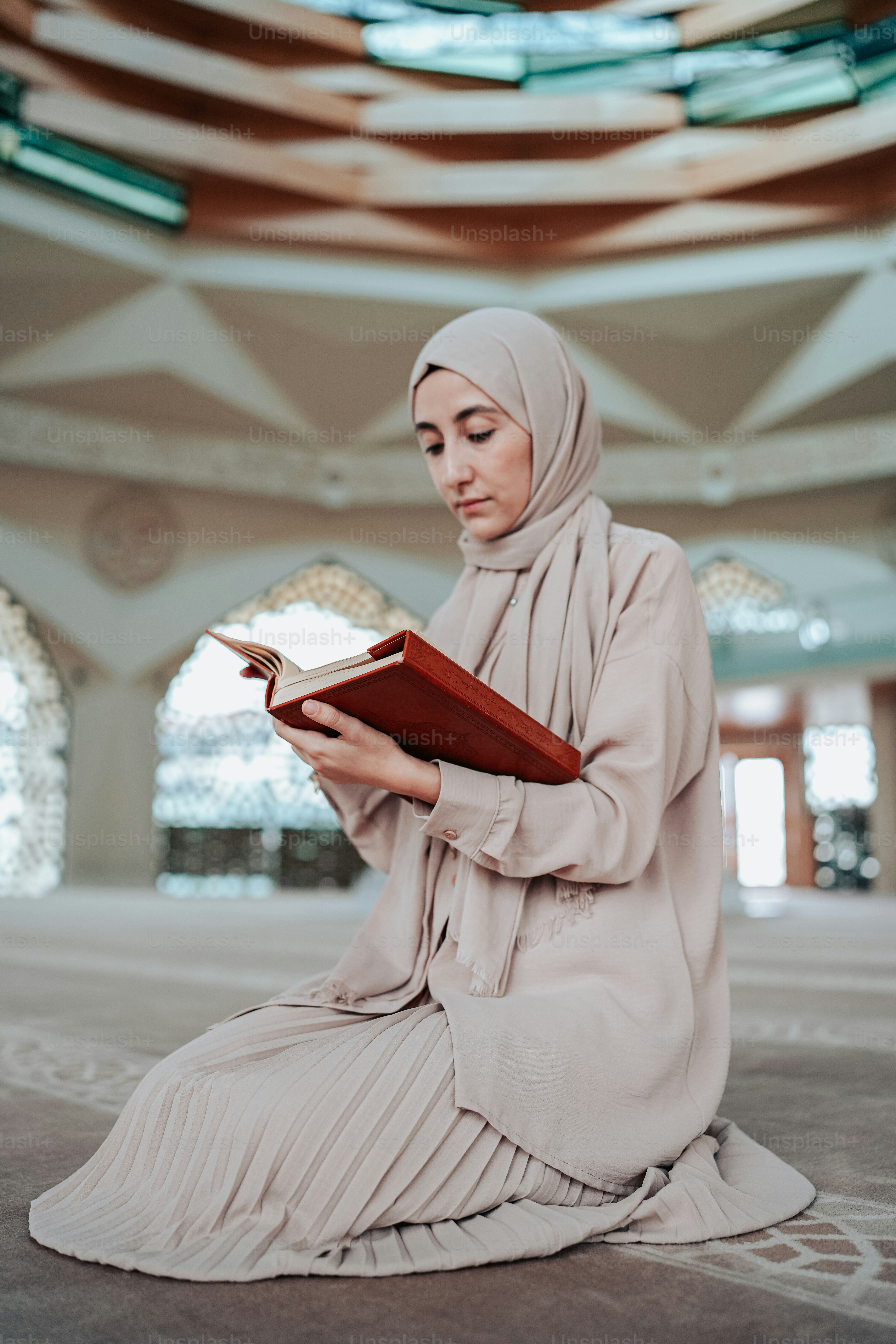 a woman sitting on the floor reading a book