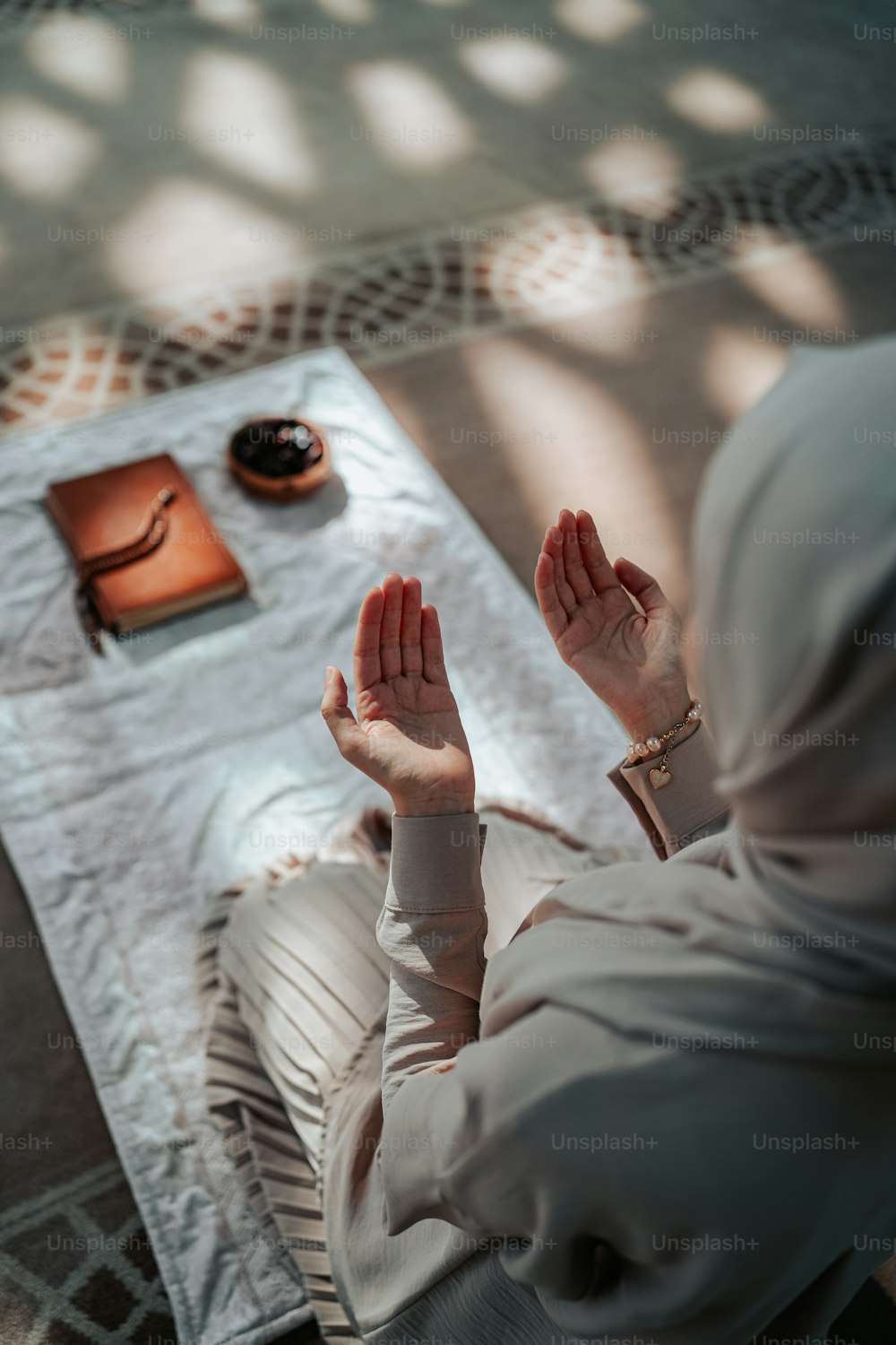 a woman sitting on the floor with her hands in the air