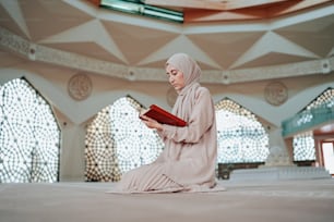 a woman sitting on the floor reading a book