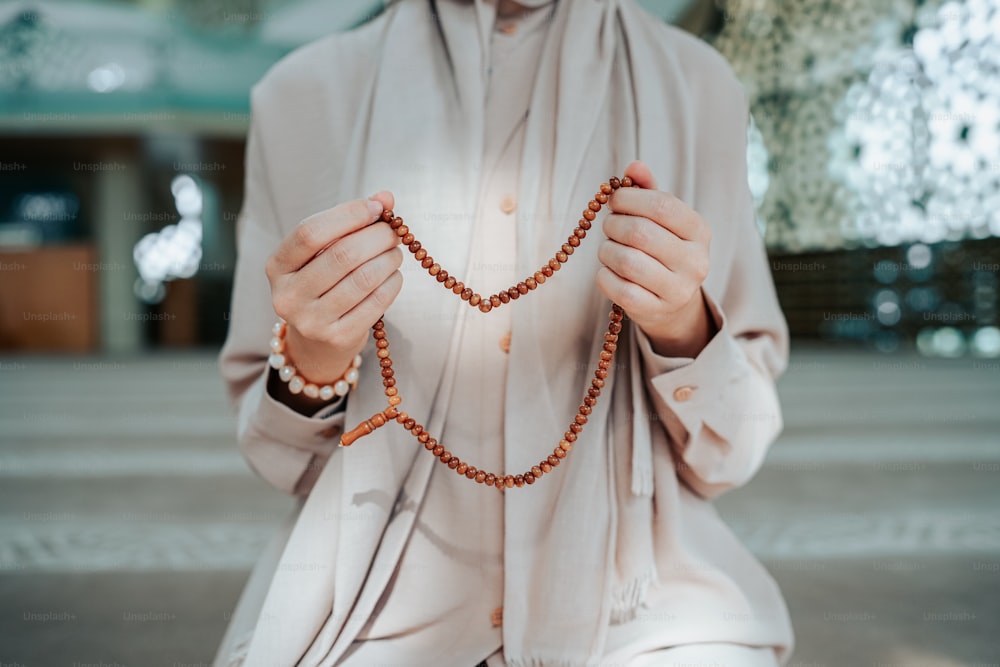 Una donna che tiene un rosario tra le mani