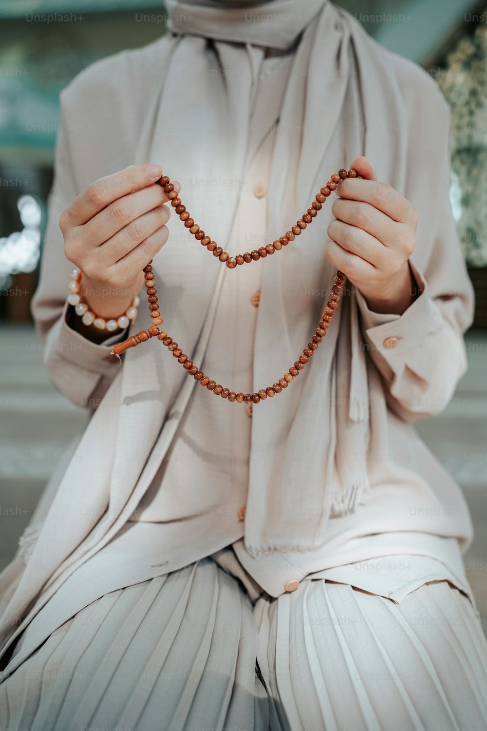 a woman in a white outfit holding a rosary