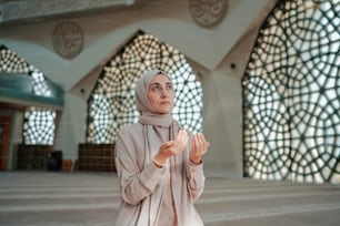 a woman in a hijab standing in a large room