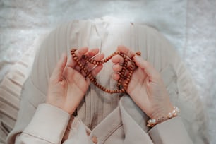 Una mujer sosteniendo un rosario en sus manos