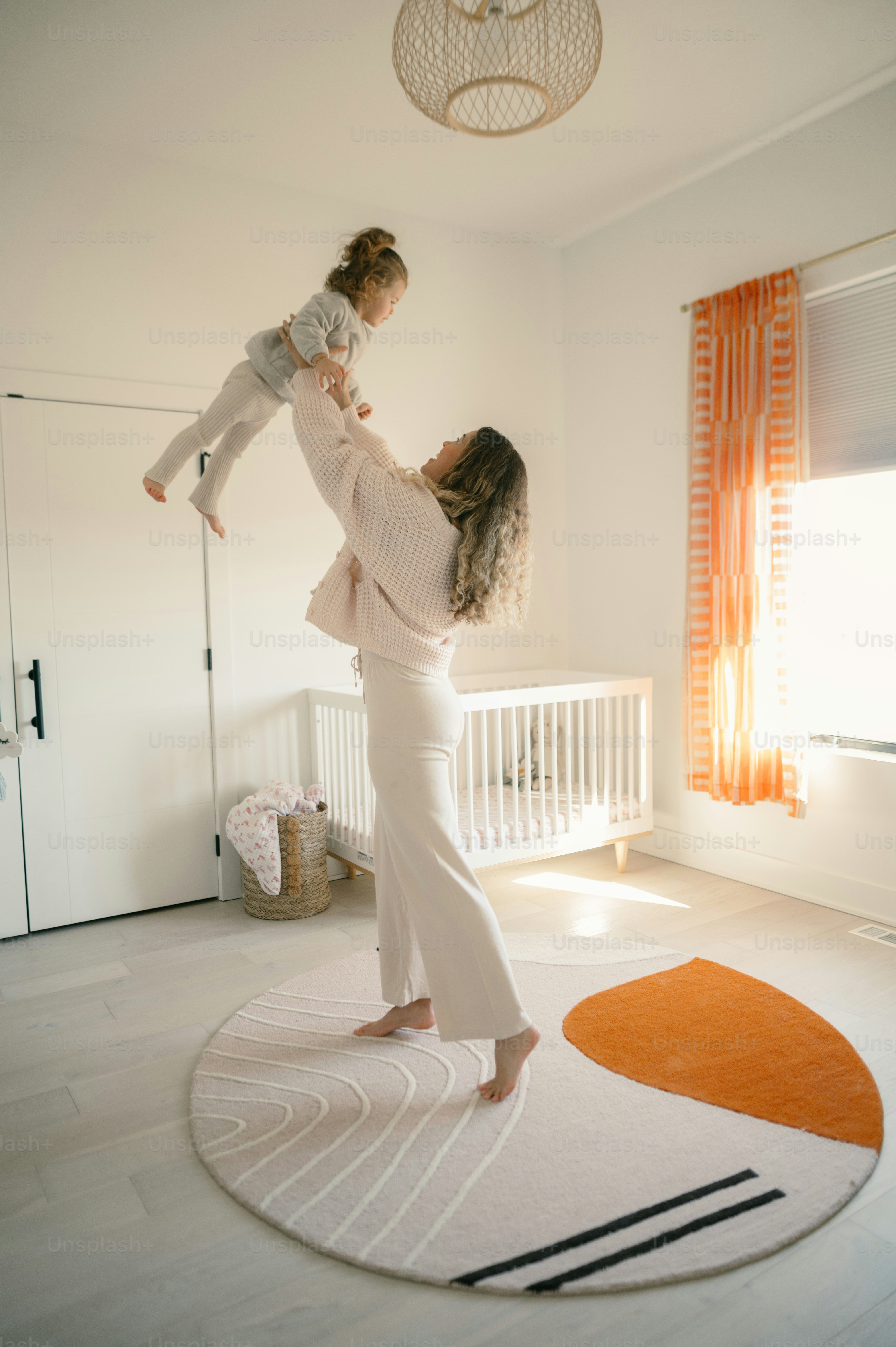 Eine Frau, die ein Baby in einem weißen Raum hält