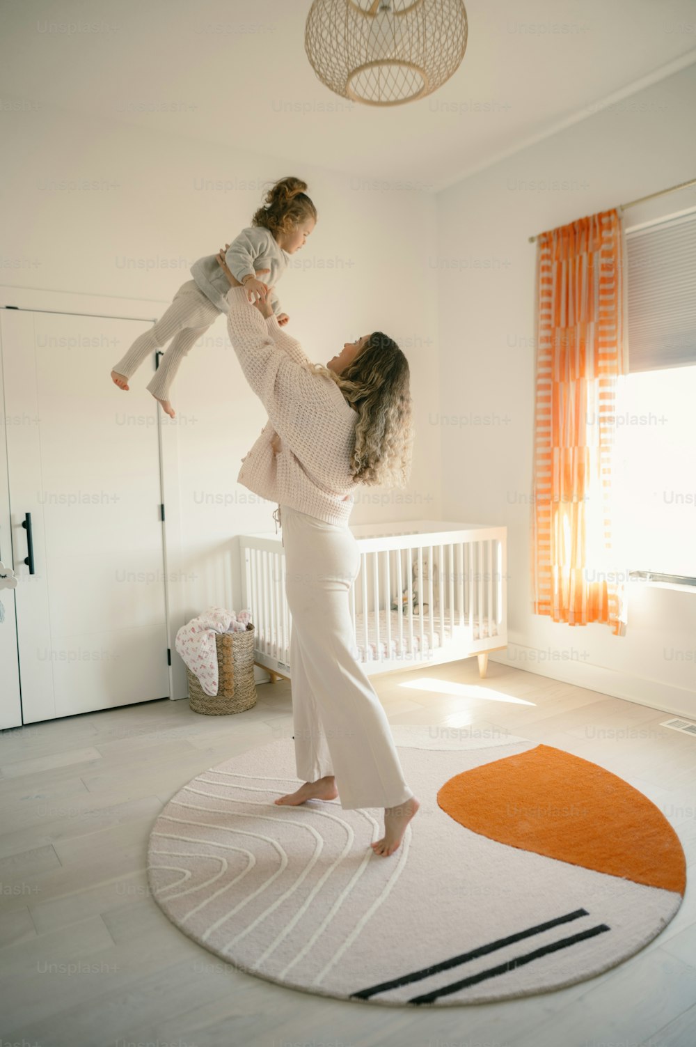 Una mujer sosteniendo a un bebé en una habitación blanca