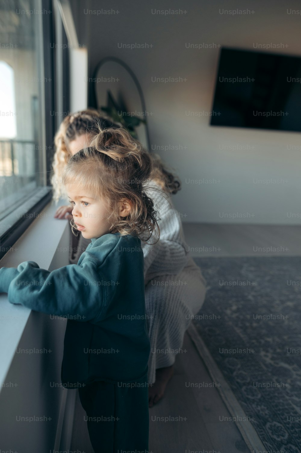 Une petite fille regardant par une fenêtre