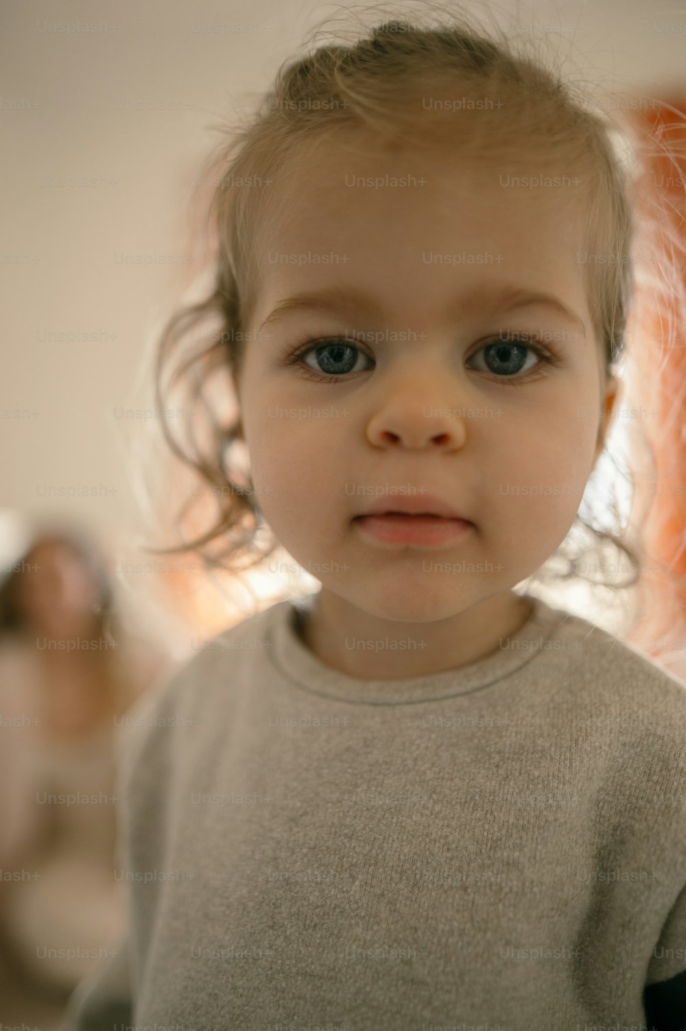 a little girl with blue eyes looking at the camera