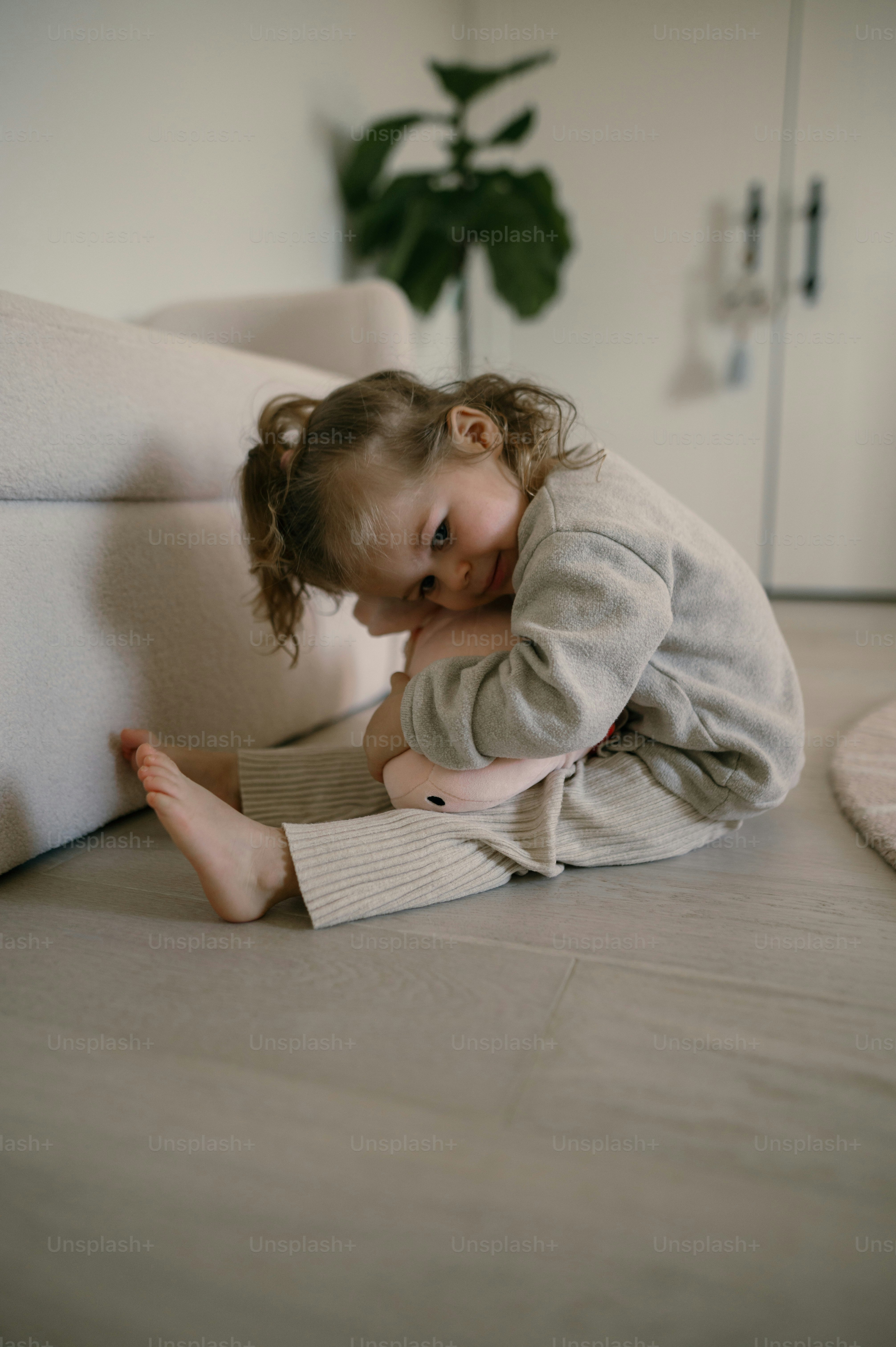 a little girl is sitting on the floor