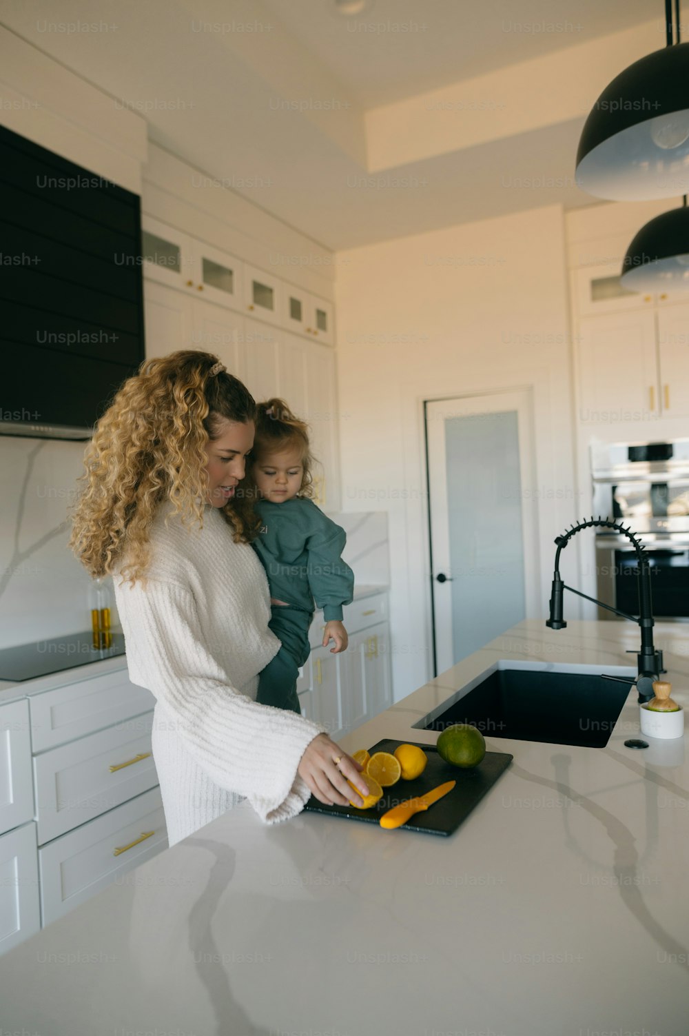 a woman holding a child in a kitchen