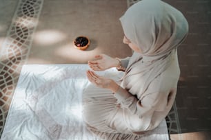 바닥에 앉아 있는 히잡을 쓴 여자