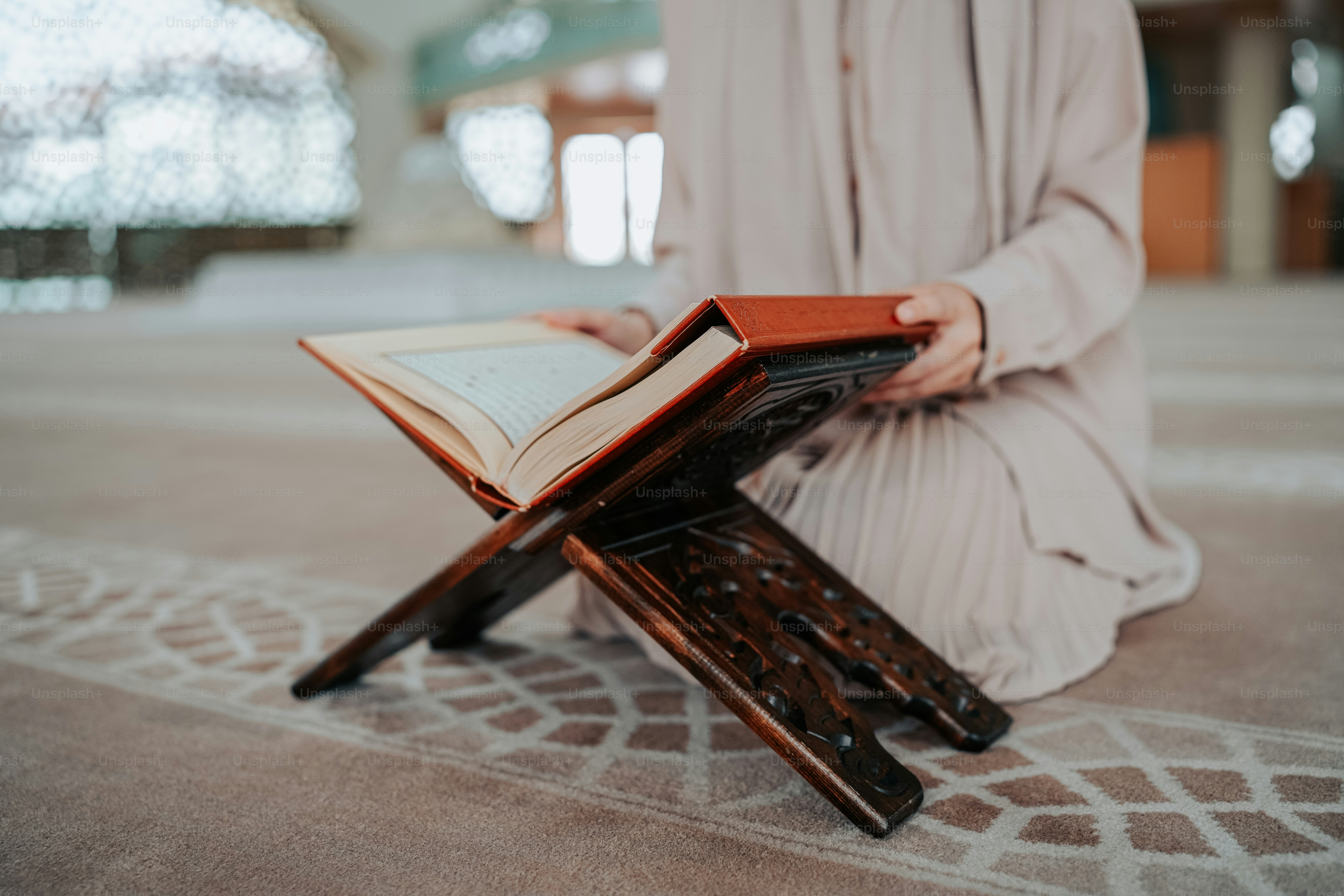 Una persona arrodillada con un libro en su regazo