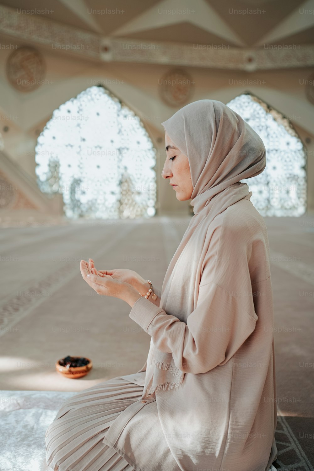 Una donna con un hijab seduta a terra