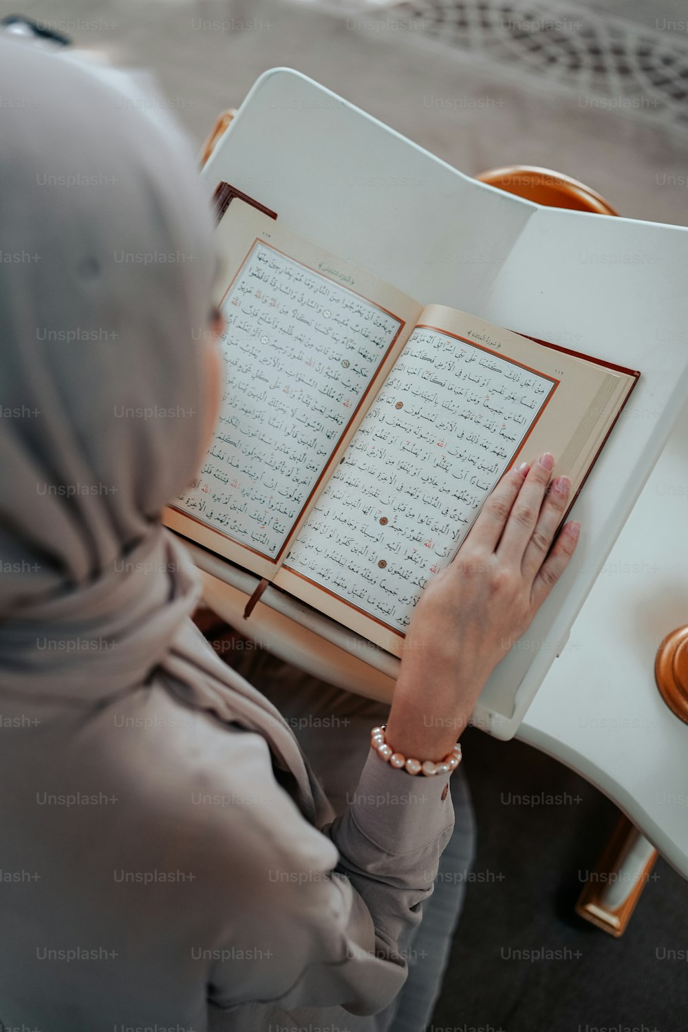 uma mulher em um hijab está lendo um livro