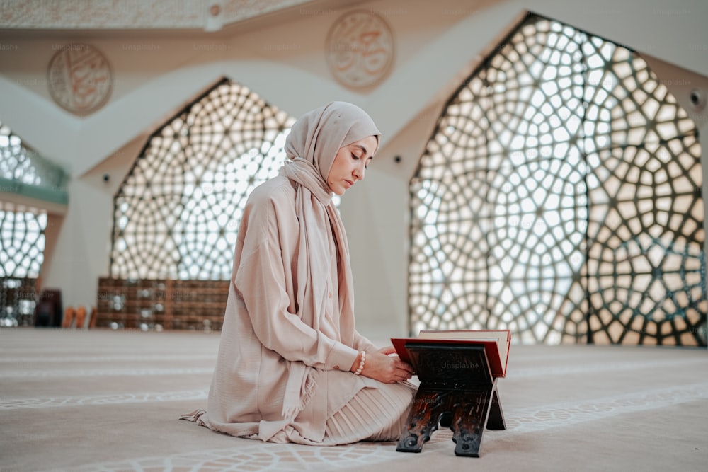 a woman sitting on the floor reading a book