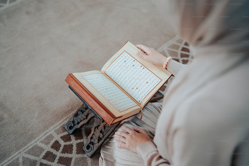 a woman sitting on the floor reading a book