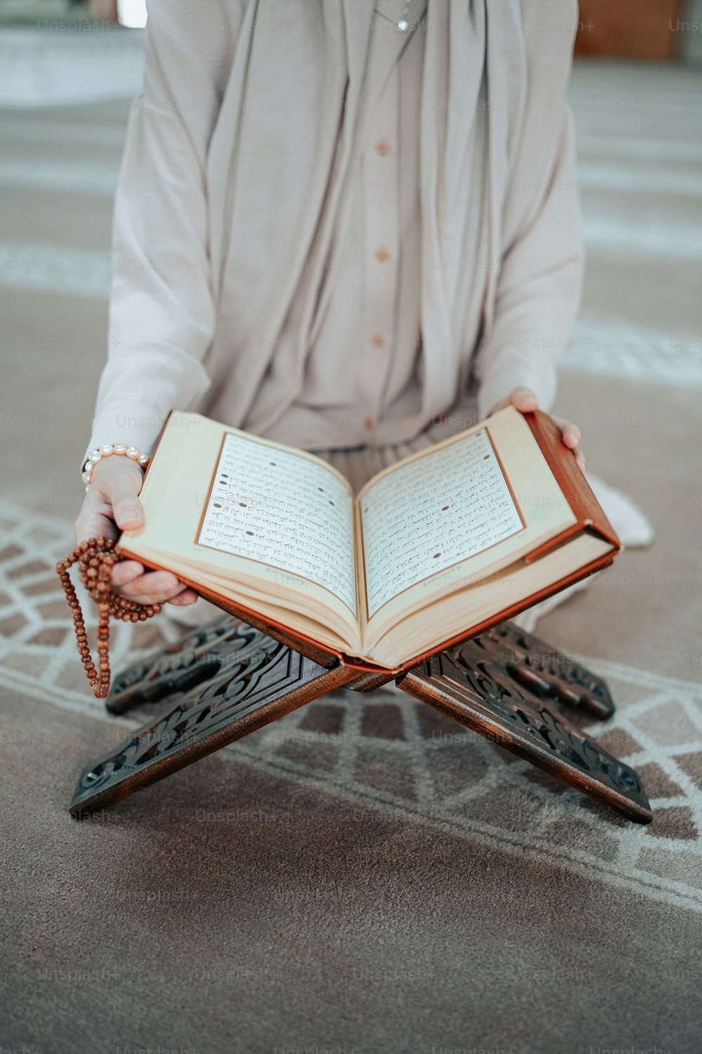 une personne agenouillée avec un livre à la main