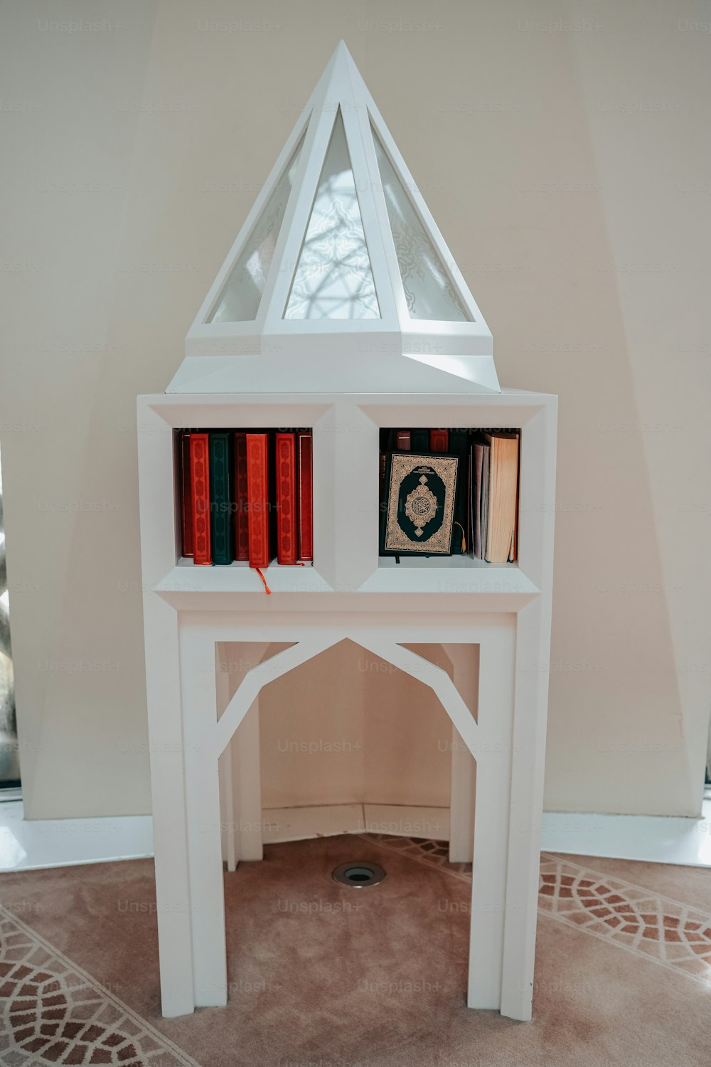 a white book shelf with books on top of it