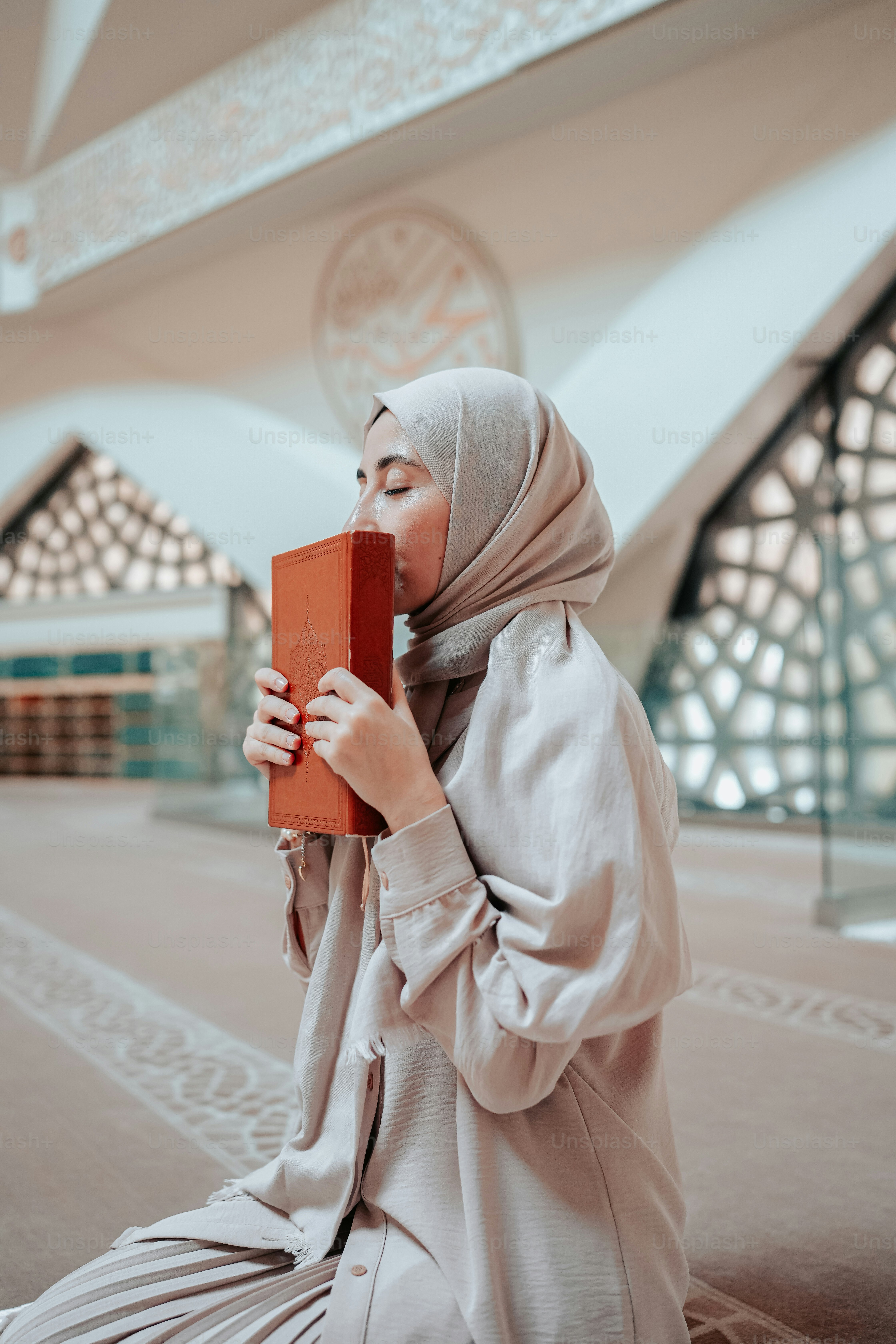 a woman in a hijab is reading a book