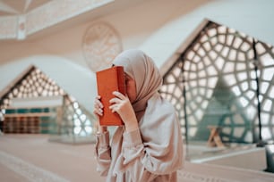 Eine Frau im Hijab hält ein Buch in der Hand