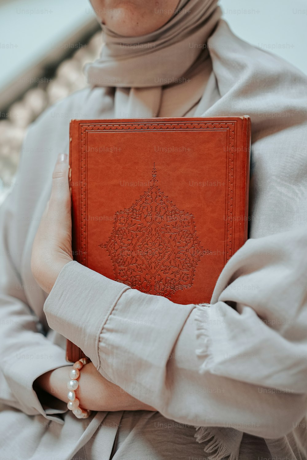 Una donna in un hijab che tiene un libro