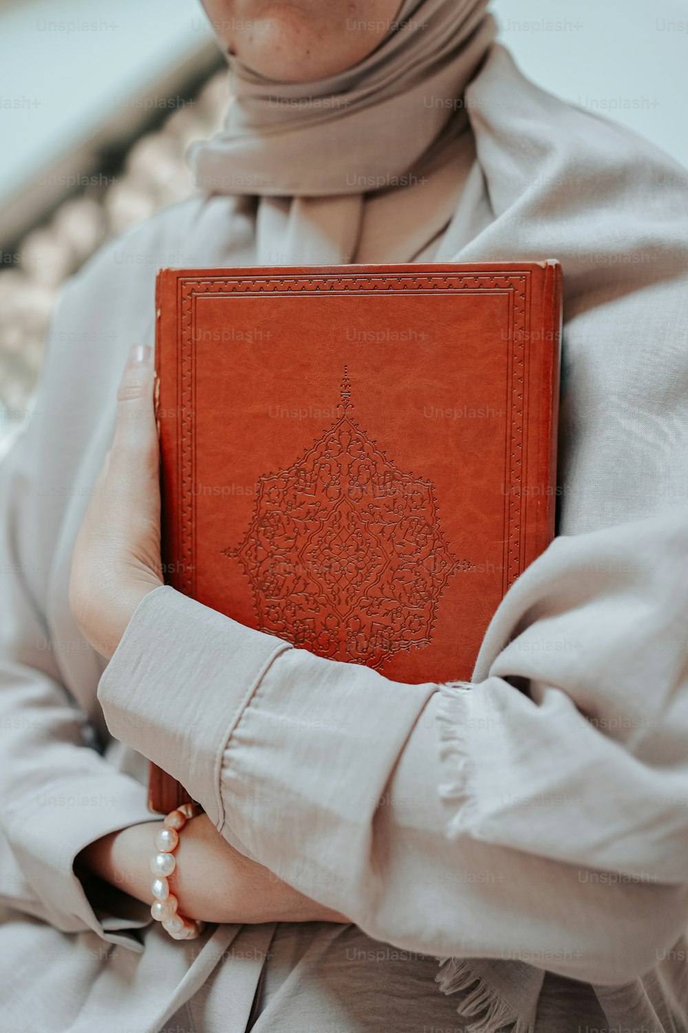 a woman in a hijab holding a book