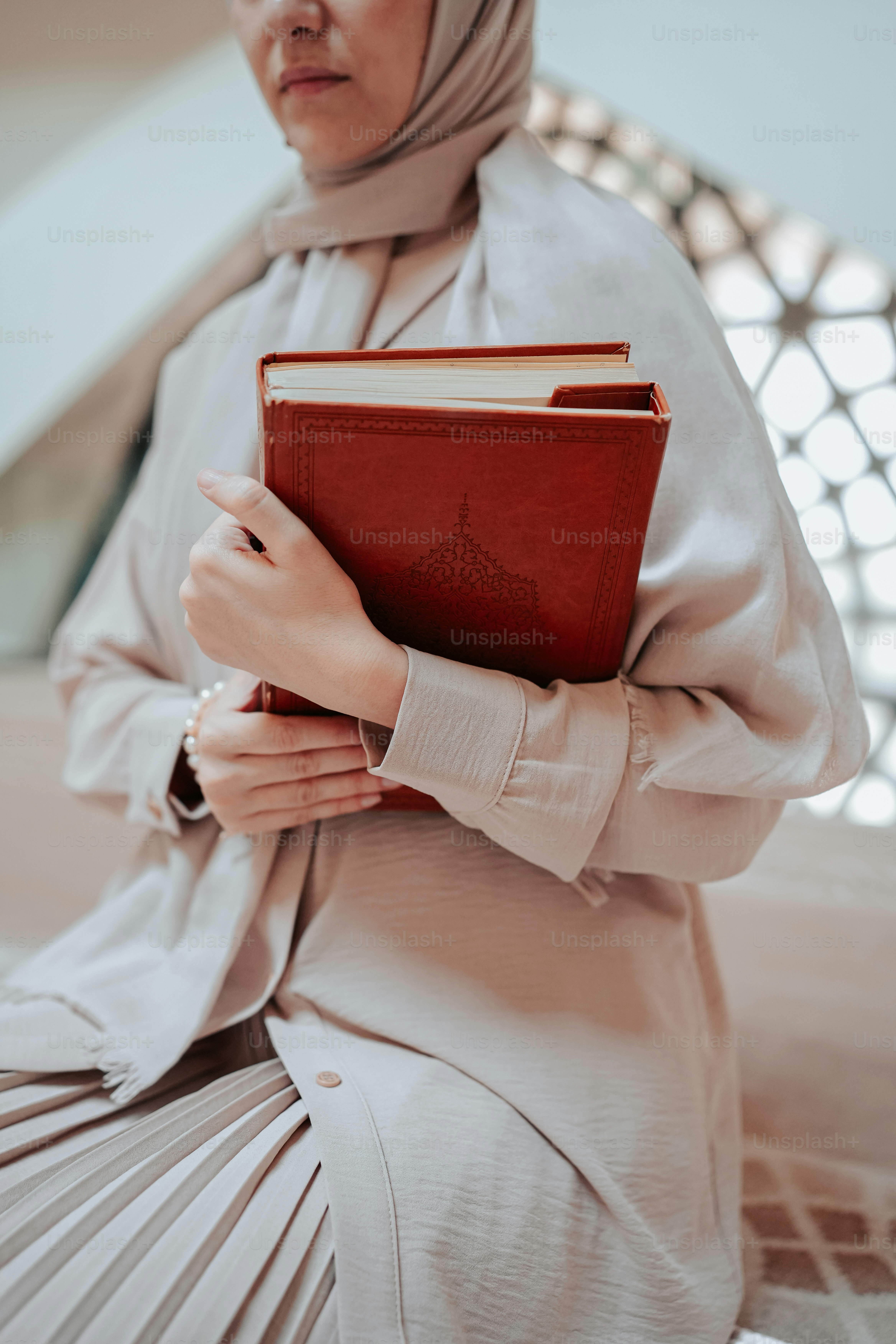 Une femme en hijab tenant un livre