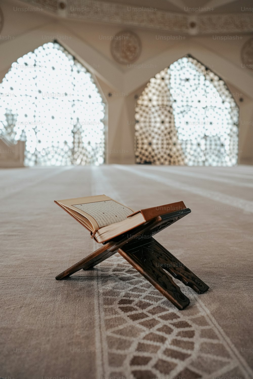 an open book sitting on top of a wooden cross