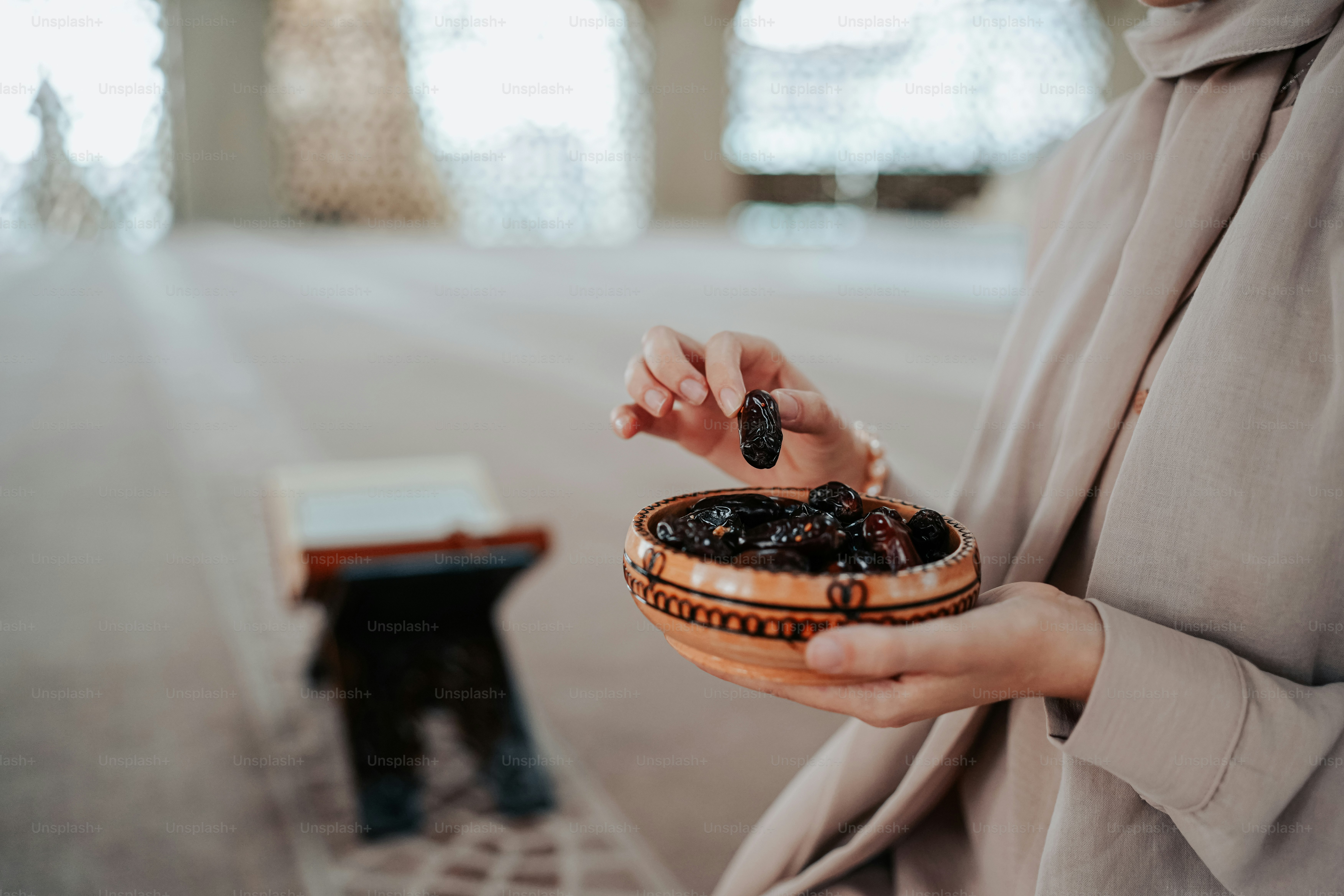 A woman holding a bowl of raisins in her hands photo – Dates fruit ...