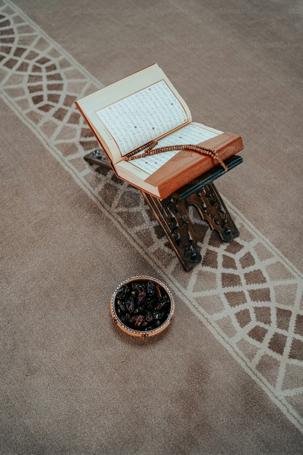 un livre ouvert et un bol de raisins secs sur le sol