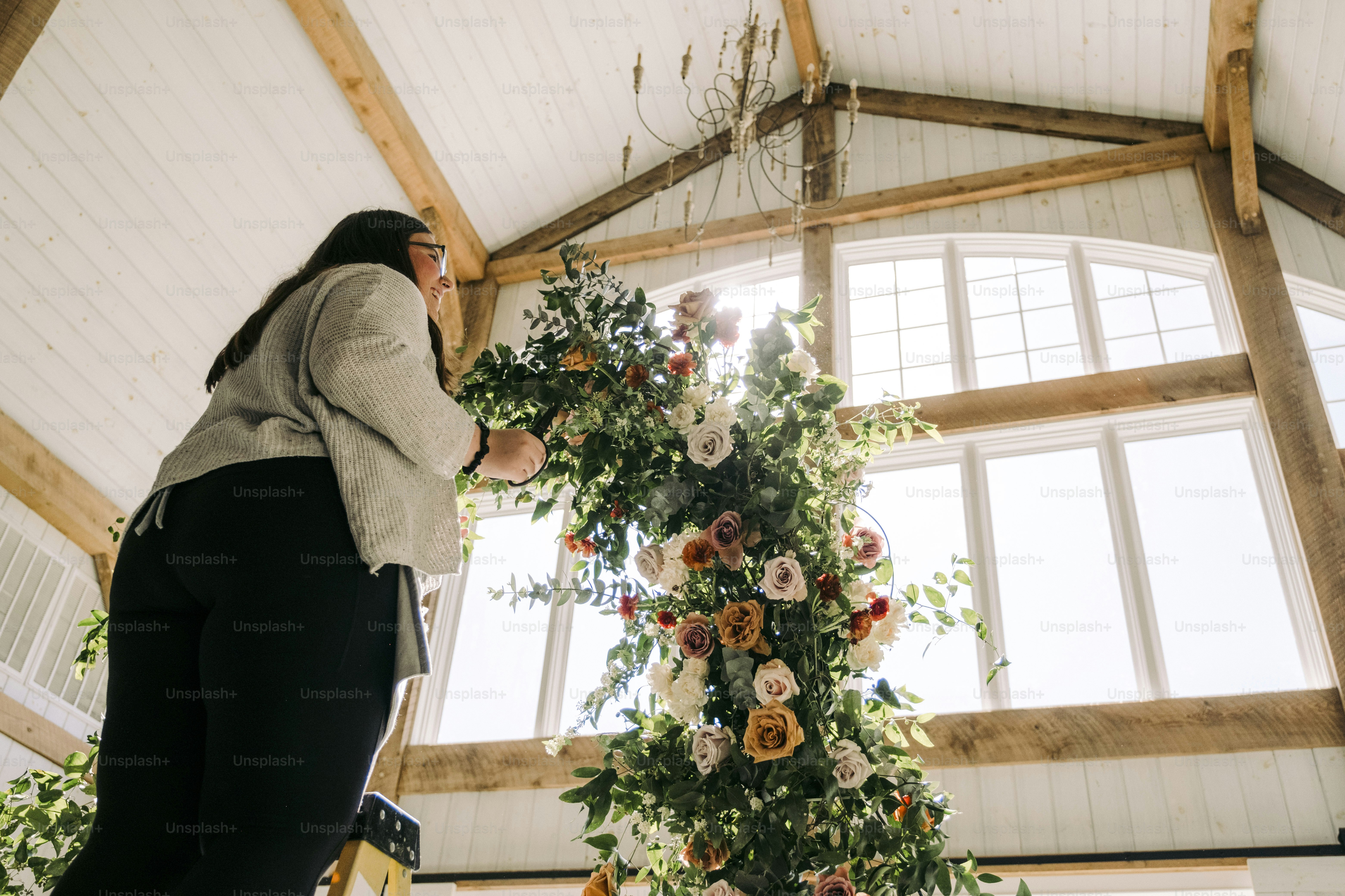 Eine Frau steht vor einem Blumenarrangement