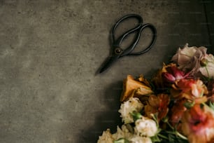 a pair of scissors sitting on top of a pile of flowers