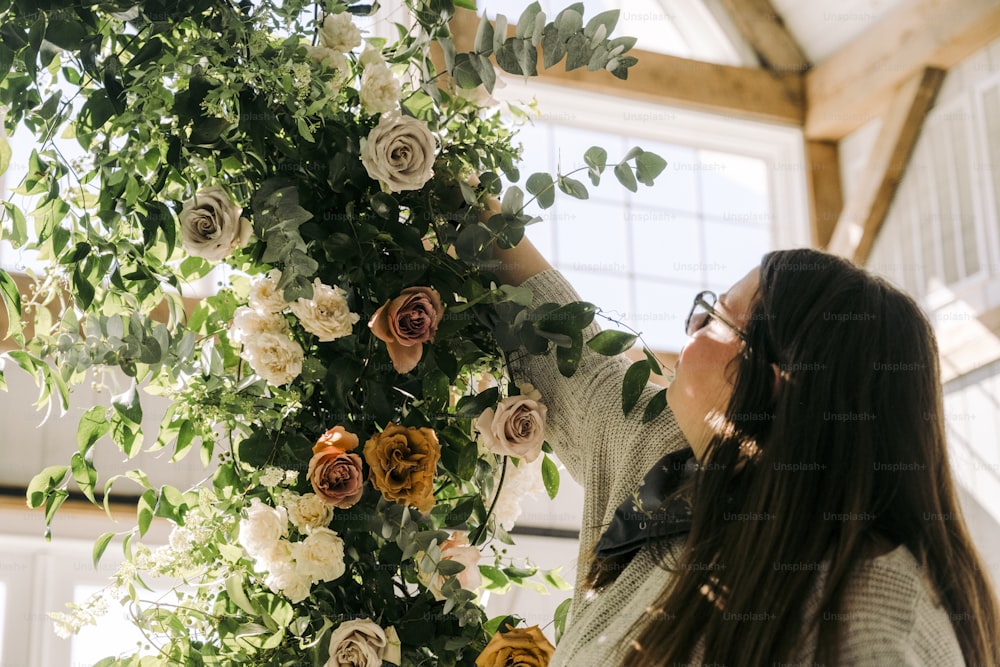 Una mujer de pie junto a un ramo de flores