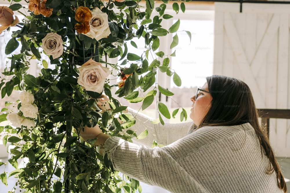 a woman arranging flowers in a room