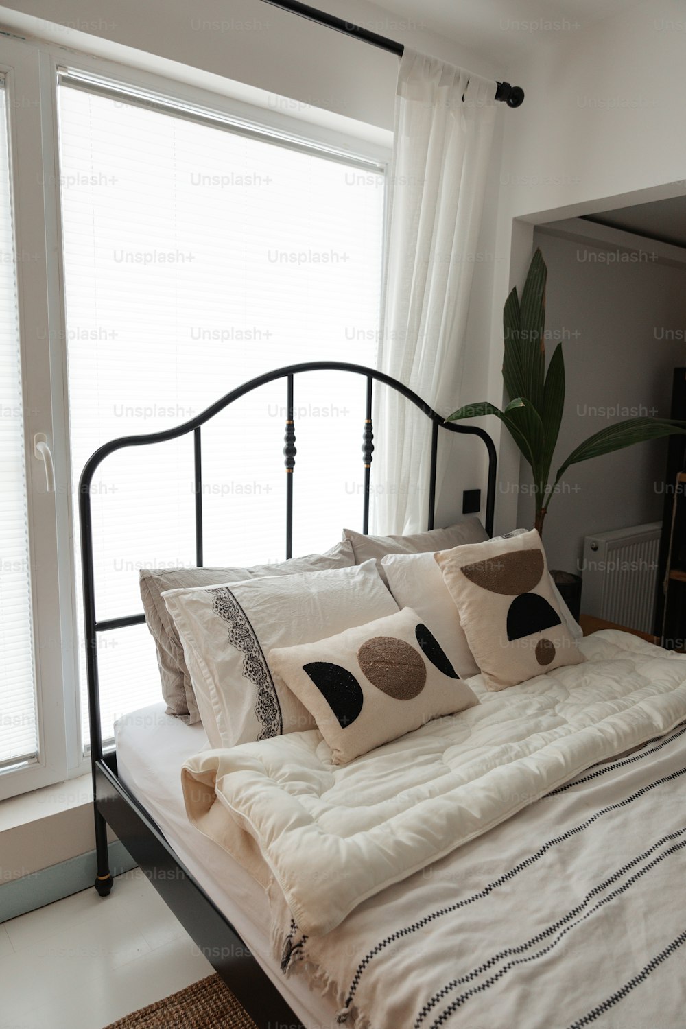uma cama com um edredom branco e almofadas