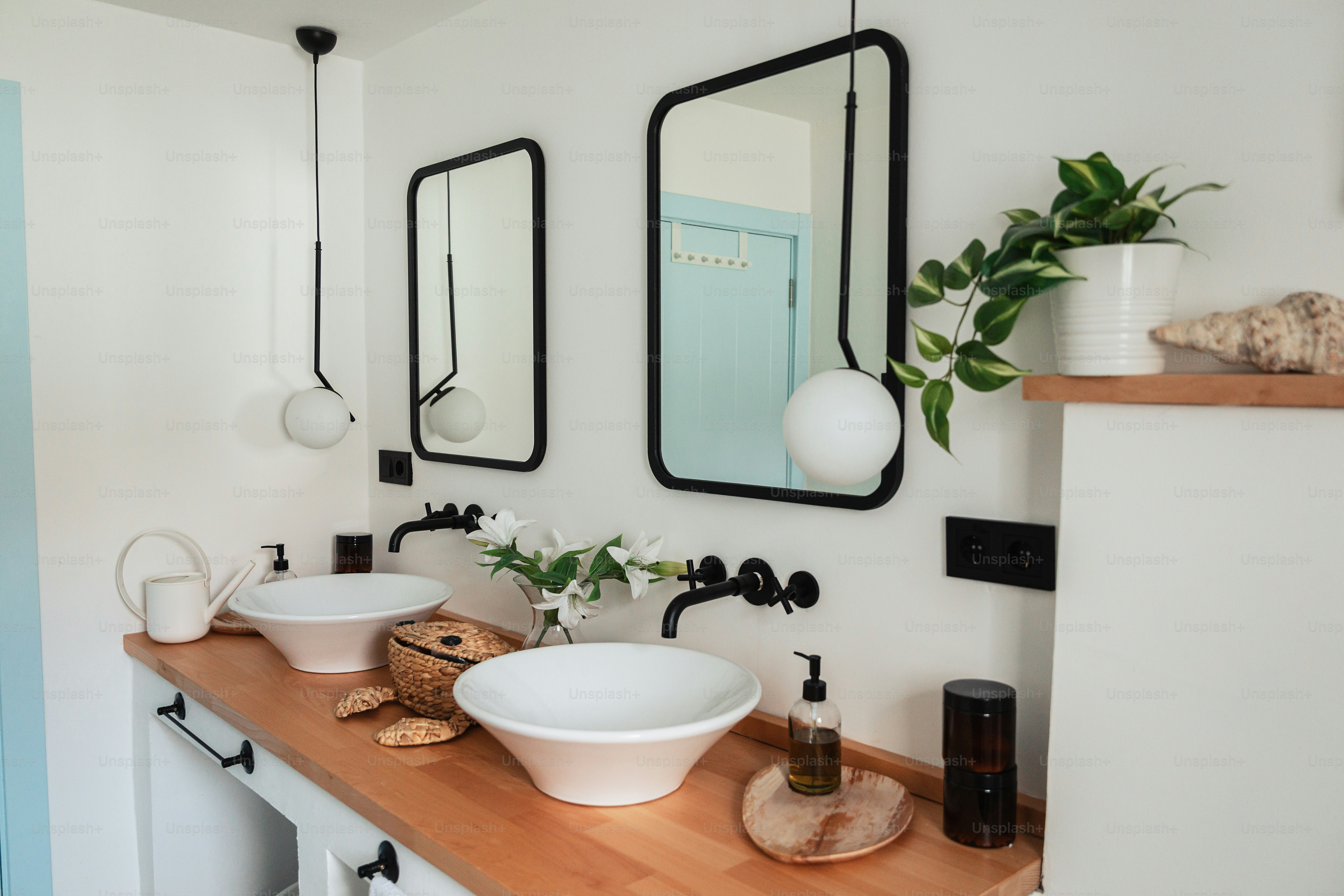 un baño con dos lavabos y espejos en la pared